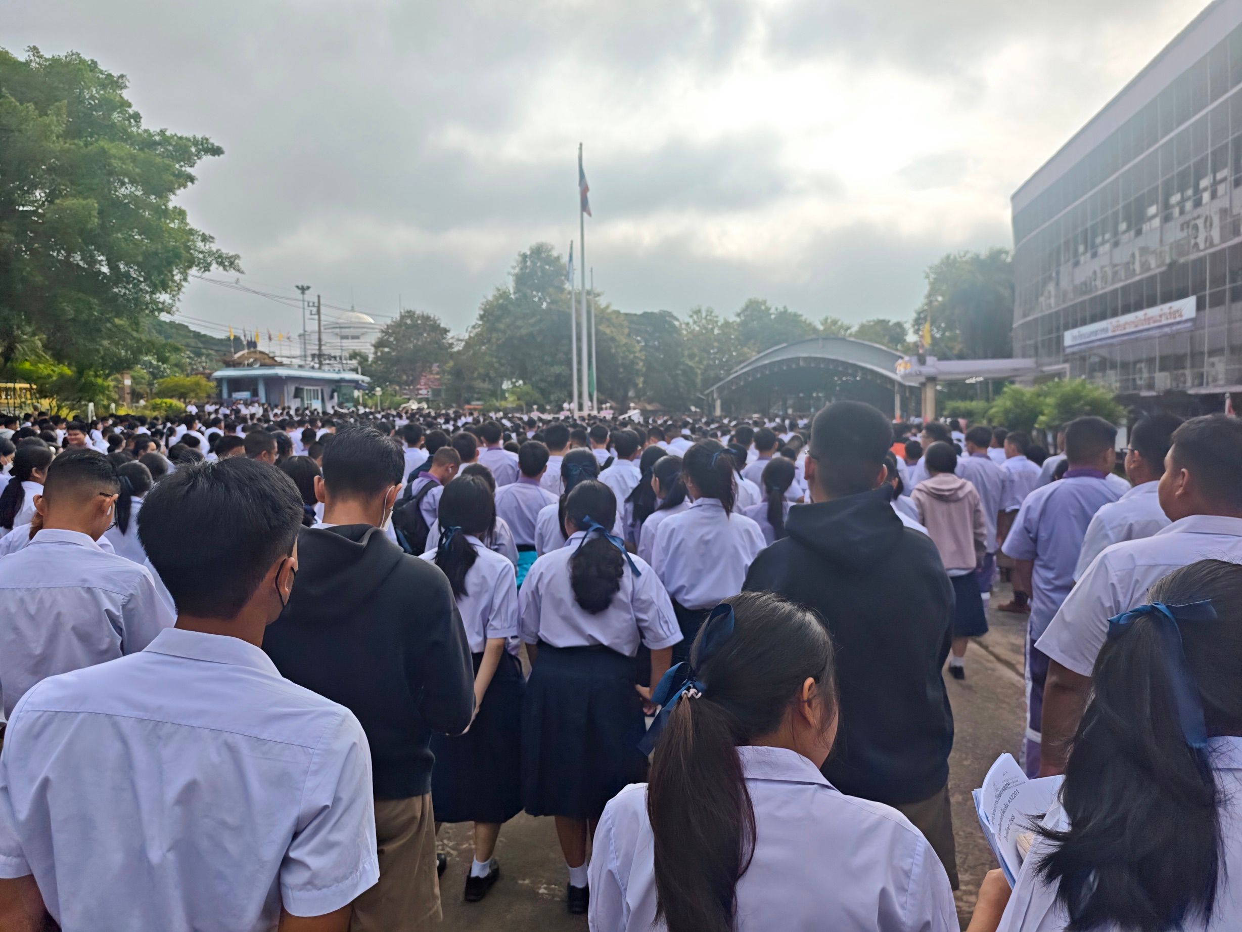 morning assembly at school. its difficult to see the true scale of the school here, even looking past the distant building isnt even half of the actual students