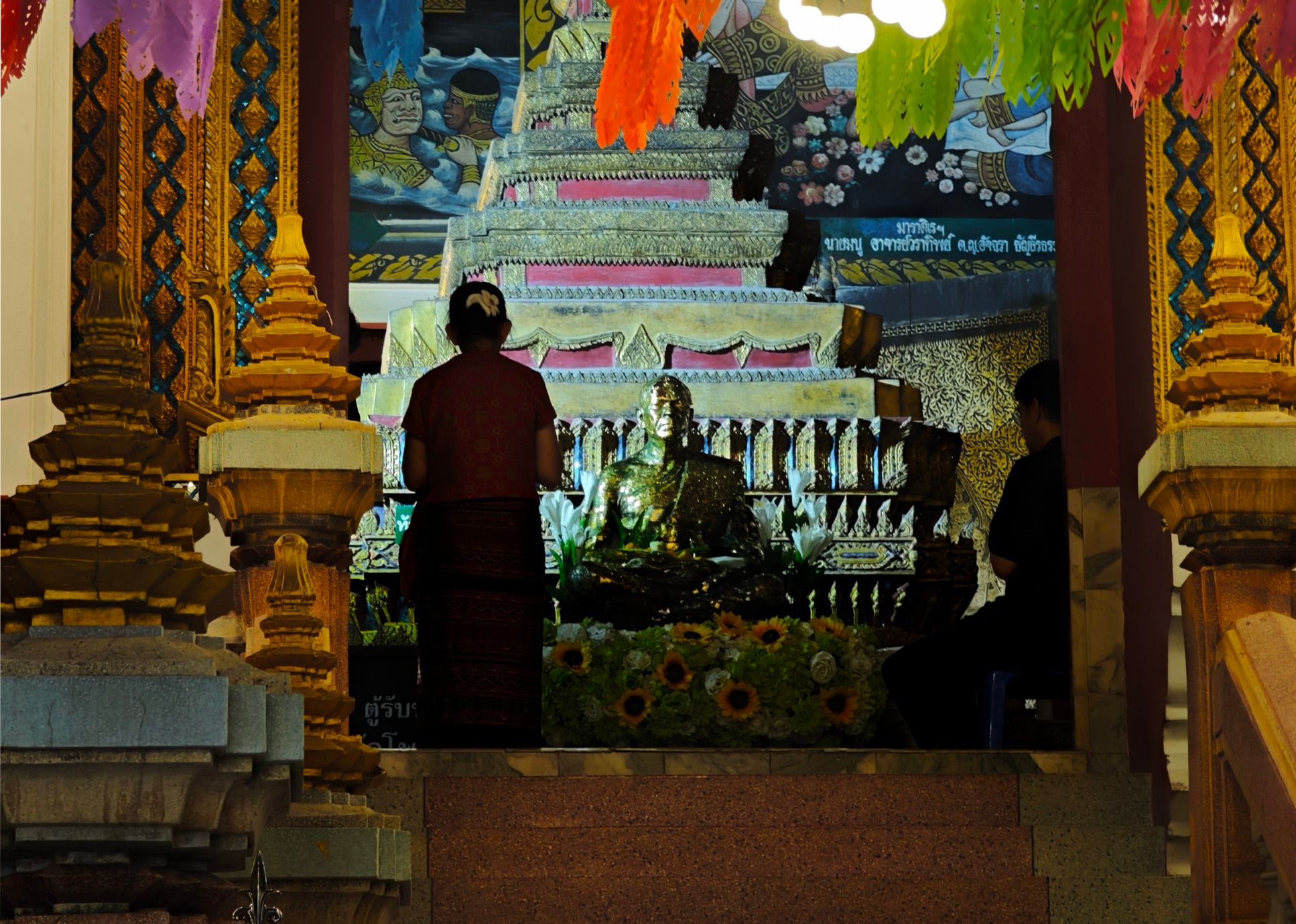 a thai woman prays in the temple just past midnight