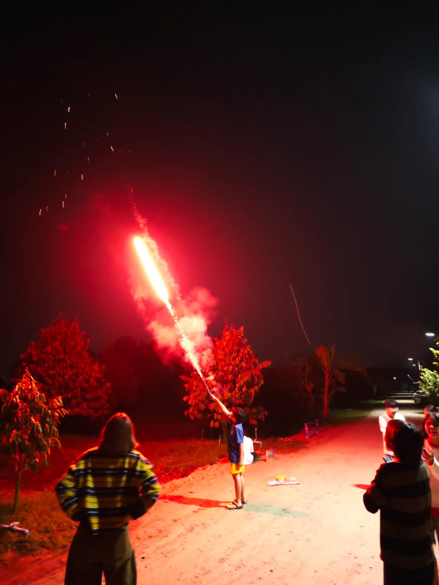 n'tonboon lighting up a roman candle on new years eve